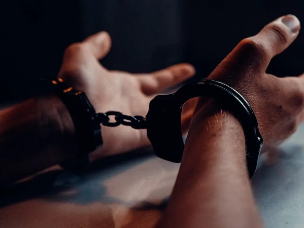 Close-up of hands in handcuffs, symbolizing larceny charges.