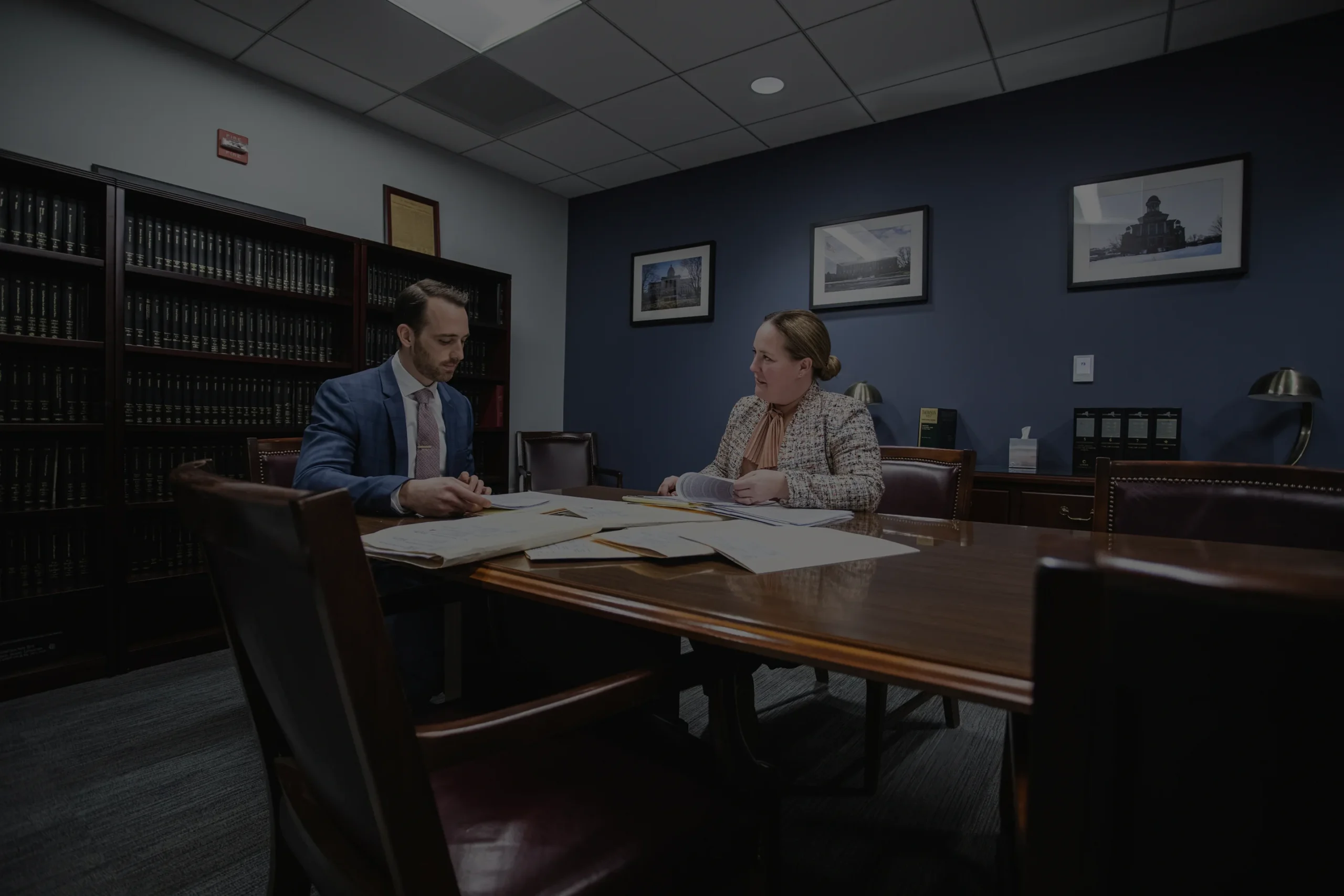 Lawyers in office reviewing case files at conference table