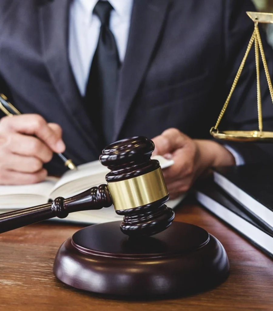 Lawyer in suit with gavel, scales of justice, and legal books