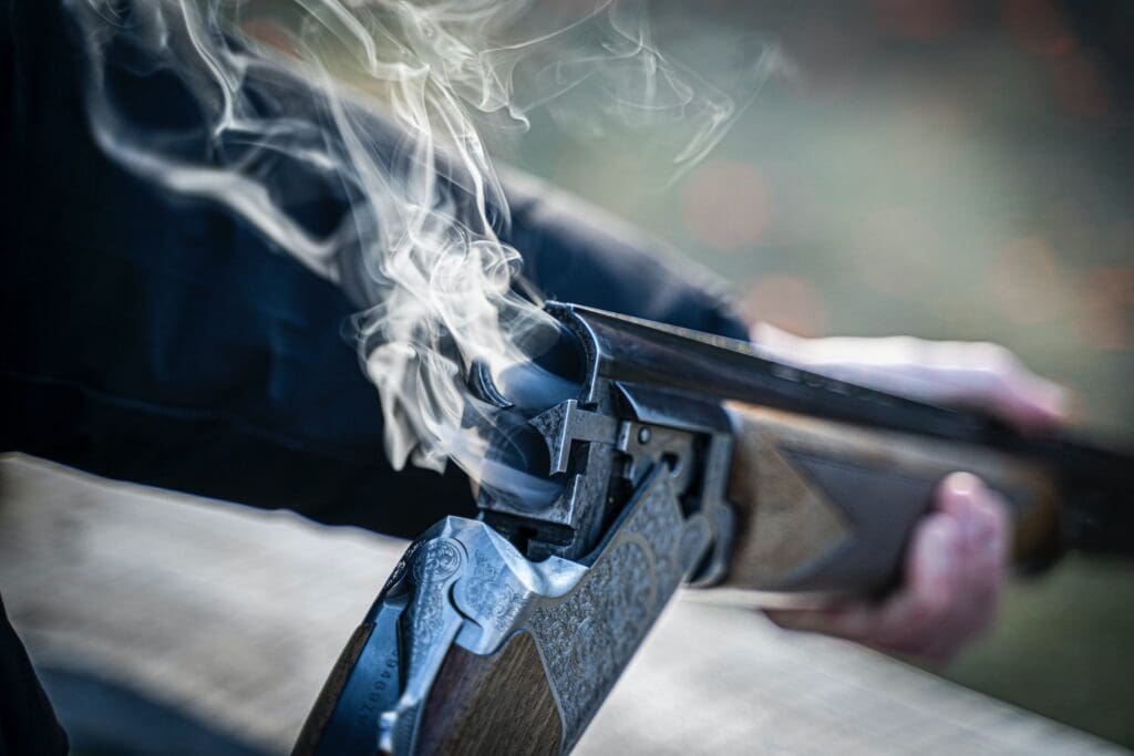 ERPO defense attorney examining a shotgun with smoke