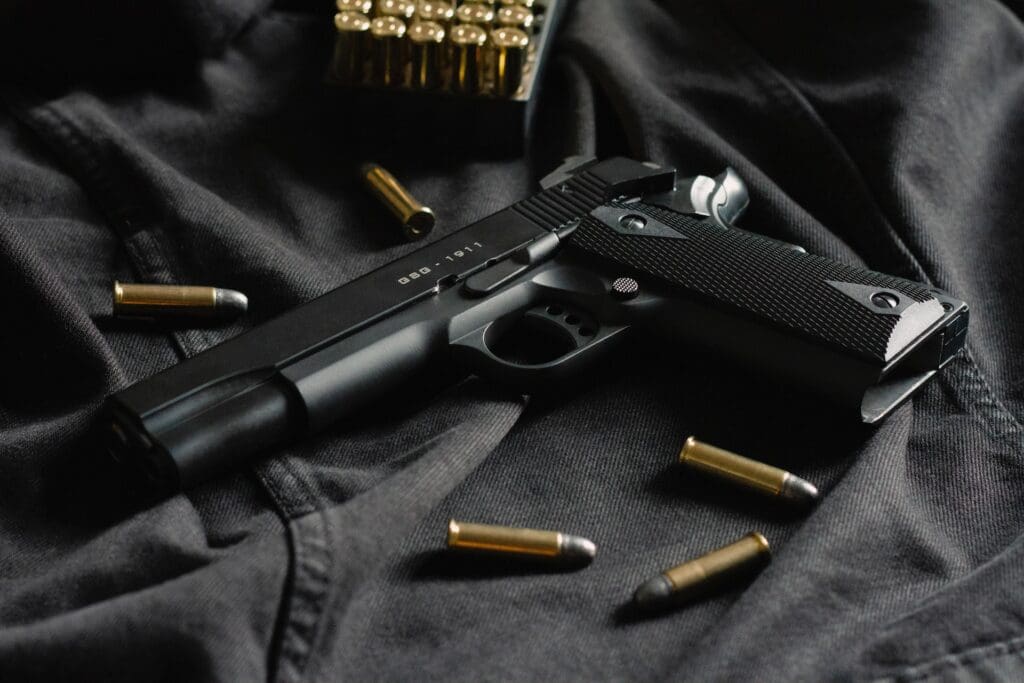 Black 1911 handgun with ammunition, relevant to weapons attorney services.