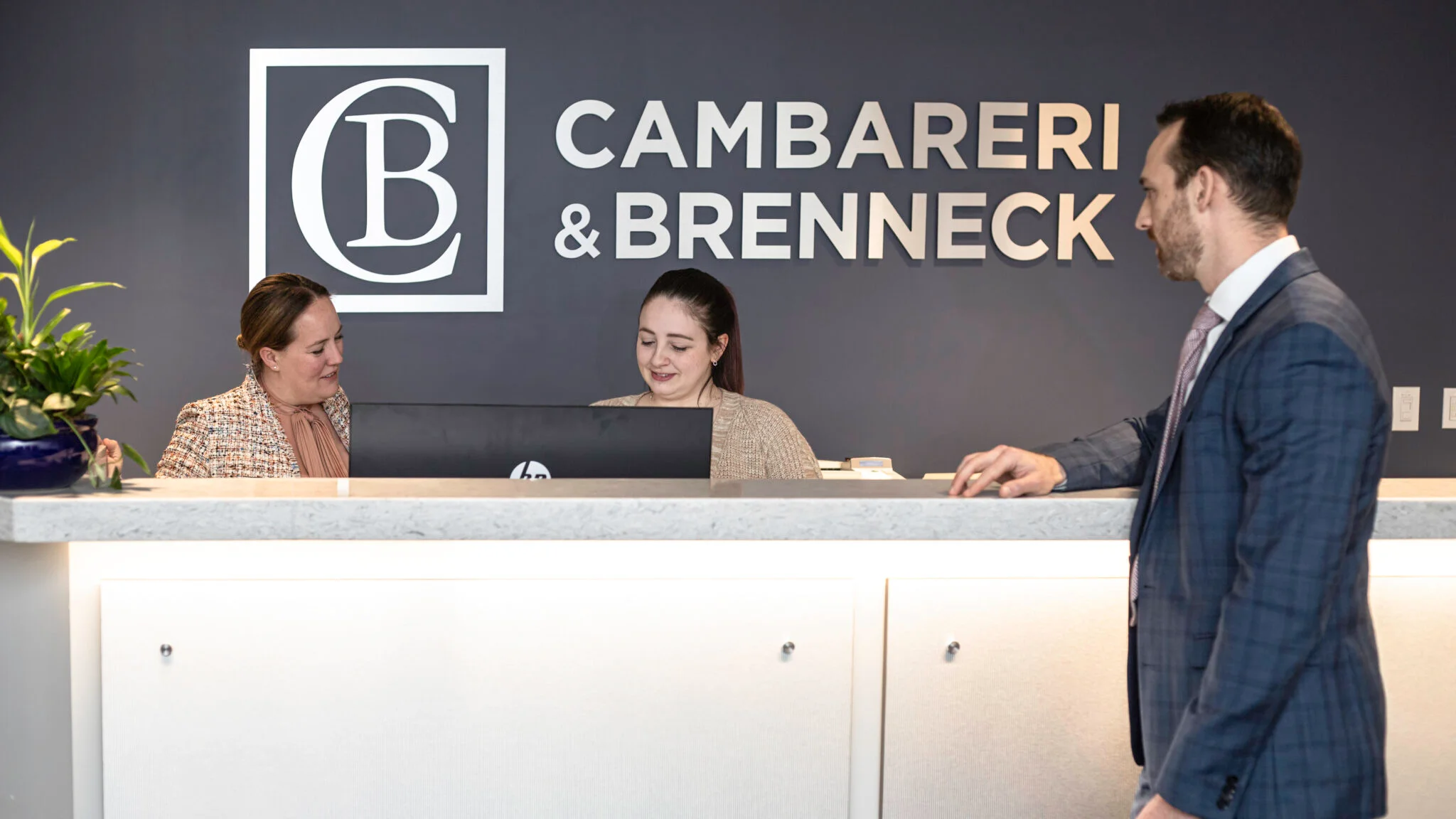 Cambareri & Brenneck reception desk with two women and a man
